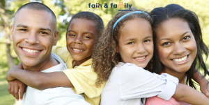 A family of four smile with the banner "Faith and Family Empowerment" above them. They are feeling more connected after starting Christian family therapy in Atlanta, GA with Faith and Family Empowerment.