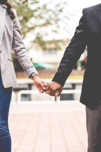 A couple holds each other's pinkies while they are walking. This is similar to discussions had in marriage counseling in Atlanta, GA with Faith and Family Empowerment. Our marriage counselors in Atlanta, GA offer effective treatment.