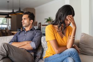 A couple sits next to each other appearing frustrated. This demonstrates concepts related to marriage counseling in Atlanta, GA. Our marriage counselors are able to assist couples struggling with communication.