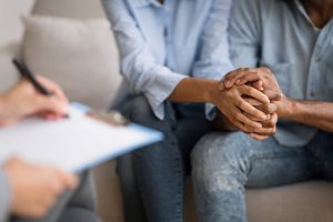 A couple hold hands as a therapist writes notes on their clipboard. This represents a therapist in Decatur, GA supporting a couple. Contact a christian therapist in Decatur, GA to learn more about online therapy in Atlanta, GA and other services today! 30071