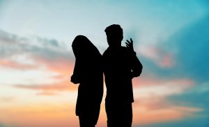 A silhouetted couple stand against the evening sky as they appear to argue. A marriage counselor in Norcross, GA can offer support to improve communication. Learn more about how Christian Marriage Counseling in Decatur, GA can help today! 30030