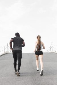 A couple run together on a bridge. Marriage counseling in Decatur, GA can help you overcoming marriage concerns. Learn more about online therpay in Georgia or therapy in Atlanta, GA by contacting a black male therapist today for more information.