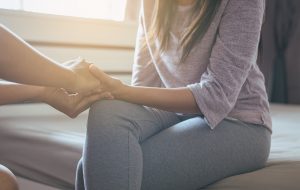Shows a woman holding her partner's hand. Represents how marriage counseling in decatur, ga will help you and your partner communicate more effectively.