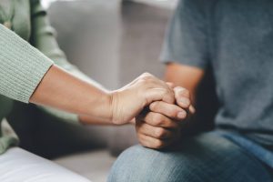 A close up of a person holding the hand of a family member. This could represent the support grief counseling in Atlanta, GA can offer. Learn more about Christian grief counseling in Decatur, GA and other services today.