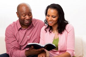 Shows a couple studying the Bible. Represents how a couples therapist in Atlanta, GA can help you find a plan that celebrates both religions.