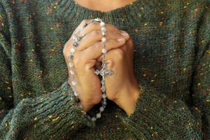 Shows a woman holding a rosary. Represents how working with a christian counselor in atlanta, ga will integrate your faith into your anxiety treatment.