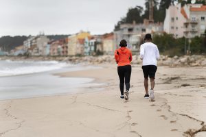 Photo of a black couple running along the beach in coastal georgia representing the power of having a supportive partner.