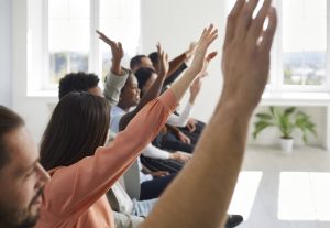 Shows a group of people raising their hands. Represents how christian counseling in atlanta, ga supports marginalized mental health with the support of a therapist in decatur, ga.