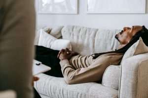 A man lies on a therapist’s couch with his eyes closed, representing emotional healing supported by a premarital counselor in Atlanta, GA and an EMDR therapist in Atlanta.