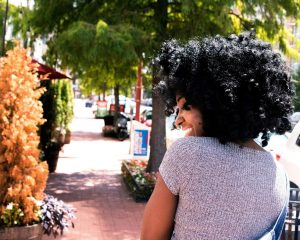 A smiling Black woman walking outdoors on a sunny day, symbolizing growth and healing through relationship therapy for one in Atlanta, GA with an EMDR therapist in Atlanta.