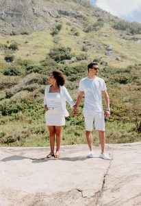 A couple standing on a rocky ledge with distant expressions, symbolizing emotional distance and the impact of imposter syndrome in relationships in Atlanta, GA.
