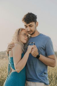 A couple standing in a field, gently holding hands and leaning into each other, reflecting the healing connection built through support from an EMDR therapist in Atlanta and guidance from a premarital counselor in Atlanta, GA.