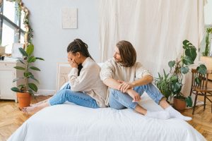 A distressed couple sits back-to-back on a bed, highlighting emotional pain and disconnection—an image representing the journey of affair recovery in Atlanta, GA with support from a skilled marriage counselor in Atlanta, GA.