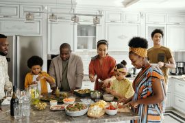 A multi-generational family preparing a meal together in a modern kitchen, symbolizing the healing support of an EMDR therapist in Atlanta for breaking family-related inner critic cycles.