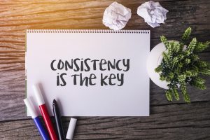A notebook on a wooden desk reads “Consistency is the key,” reminding college students in emdr therapy in atlanta to keep showing up for sessions with an emdr therapist in atlanta, whether they’re working with a christian therapist in decatur, ga or another trusted provider.