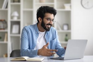 A young adult talks and smiles during a virtual session with an emdr therapist in atlanta, engaging in online therapy atlanta with an online therapist in decatur, ga who helps him stay grounded during college breaks.