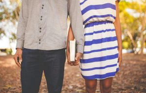 A couple holding hands outdoors in an autumn park, representing hope and connection through decatur marriage counseling with a marriage counselor in atlanta, ga who helps couples heal from church hurt and spiritual trauma.