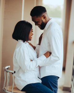 A Black couple in matching white shirts laughs and embraces closely while looking into each other's eyes, representing the warmth and reconnection that is possible when working through imposter syndrome in relationship in decatur, ga with a marriage counselor decatur ga at Faith and Family Empowerment.