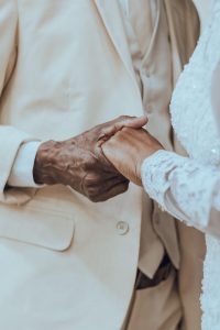 An older Black couple holds hands closely in formal attire, representing the enduring connection and renewed intimacy that affair counseling atlanta and christian marriage counseling in decatur, ga at Faith and Family Empowerment can help couples rediscover.