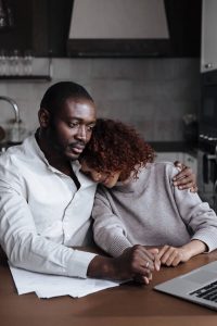 A Black couple shares a quiet moment of connection at their kitchen table as the woman rests her head on her partner's shoulder, representing the everyday intimacy that a marriage counselor decatur ga and marriage intensive decatur at Faith and Family Empowerment can help couples rediscover.