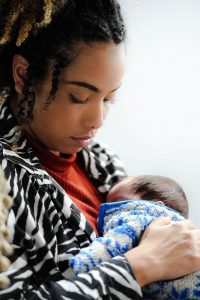A young Black mother gazes quietly at her newborn, representing the emotional weight of the postpartum season that marriage counseling in decatur, ga and a marriage counselor decatur ga can help couples navigate.